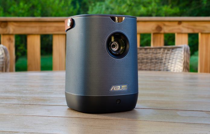 An ASUS portable projector sitting on an outdoor table