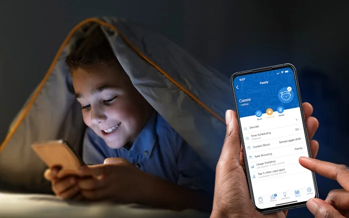 A child underneath a blanket using a smartphone while a nearby parent uses the advanced parental controls in the ASUS router app to manage screen time