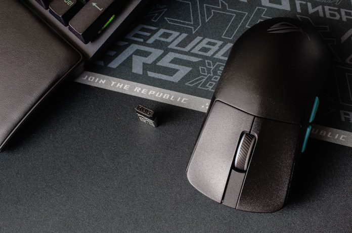 The ROG Harpe Ace Aim Lab Edition gaming mouse on a gaming mousepad next to the ROG Omni Receiver