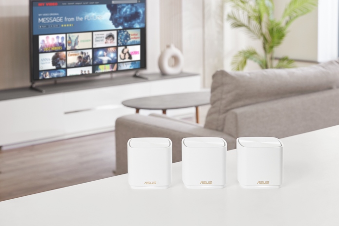 Three ASUS ZenWiFi mesh system units on a table in a living room
