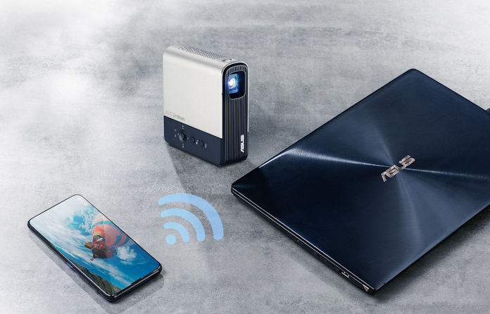 The ZenBeam E2 projector on a table with an ASUS laptop and smartphone