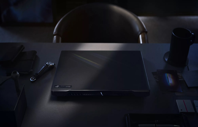 ROG Zephyrus M16 gaming laptop on a desk with tools for professional creative work and a cup of coffee