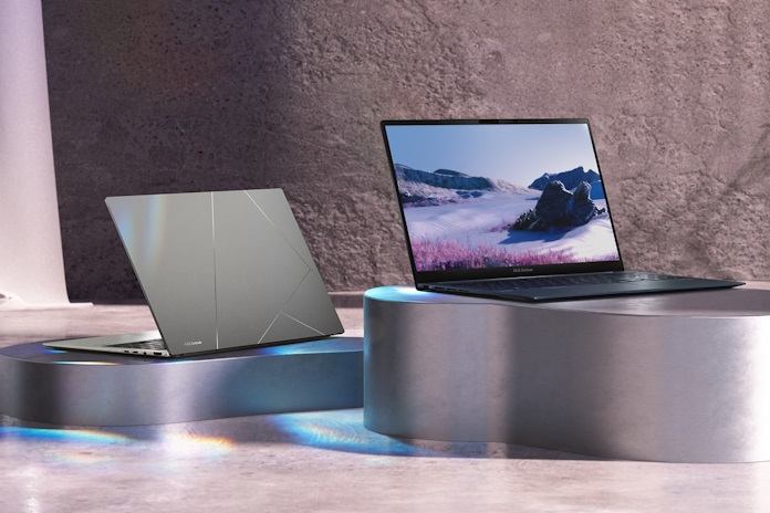 Two Zenbook 15 laptops on metal pedestals against a stony background