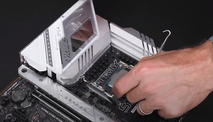 A man installing an Intel Core i9-14900K CPU into the ROG Strix Z790-A Gaming WiFi motherboard