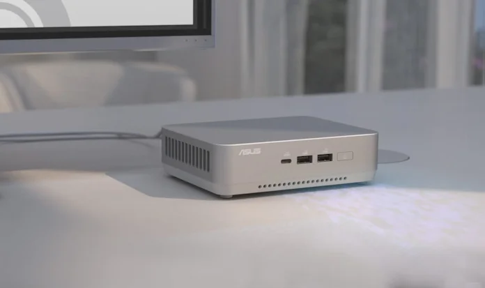 An ASUS NUC 14 Pro+ underneath a workstation monitor on a white desk