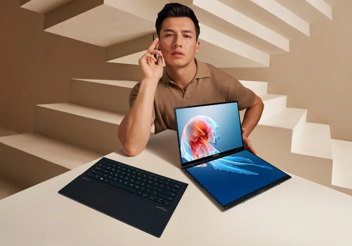 A man sitting behind the Zenbook Duo laptop with the ErgoSense keyboard detached nearby