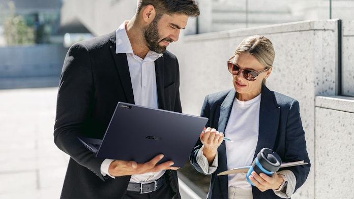 A man and a woman looking at content together on a business laptop