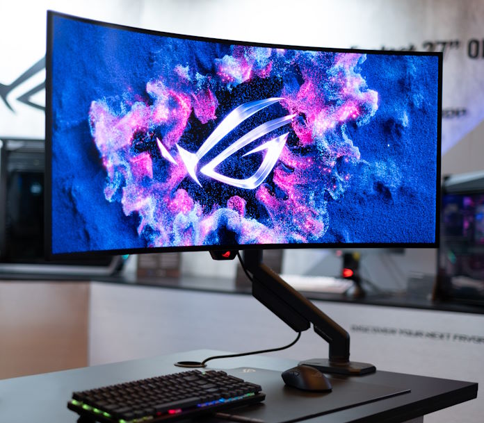 The ROG Swift OLED PG39WCDM gaming monitor attached to a desk using the ROG Ergo Monitor arm
