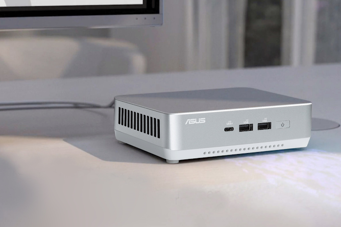 A closeup view of the ASUS NUC 14 Pro+ Mini PC on a desk underneath a monitor