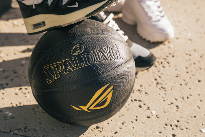 An ROG x Spalding basketball under the foot of a young person