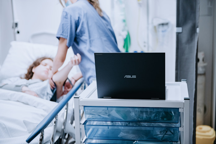 A nurse interacting with a patient on a hospital bed 