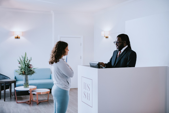 A patient interacting with staff at a checkin station at a medical institution 