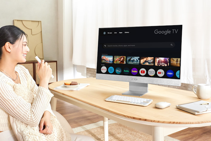 A woman using the voice-controlled remote to change the Google TV content on her ASUS display