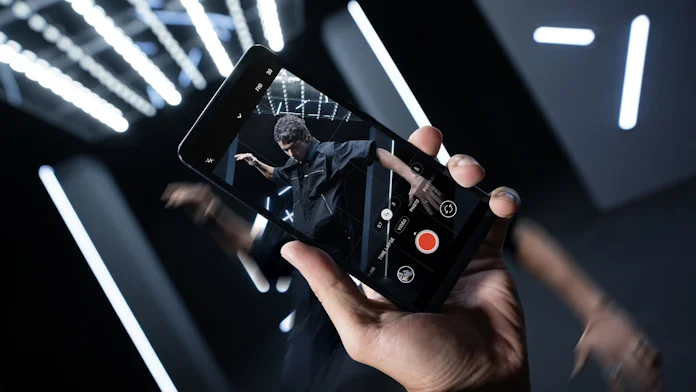 A young person taking a picture with the ROG Phone 8 Pro gaming smartphone