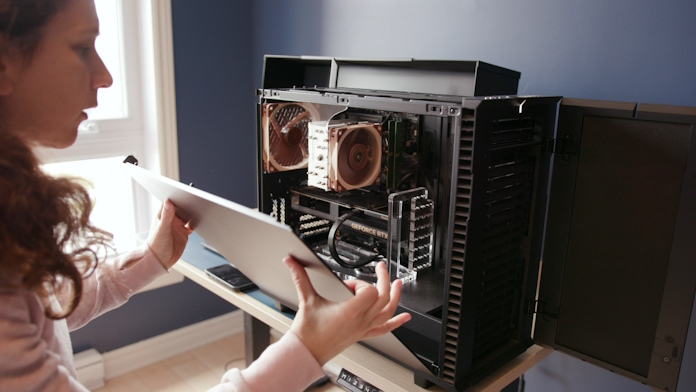 A DNEG employee opening the side panel of a Powered By ASUS Puget Systems workstation