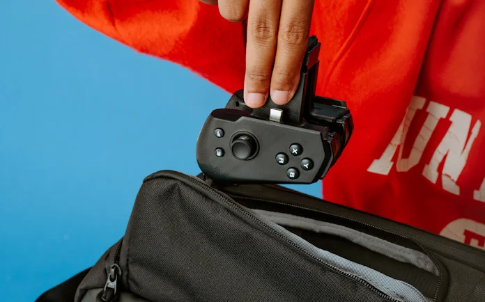 The ROG Tessen mobile controller being pulled out of a backpack