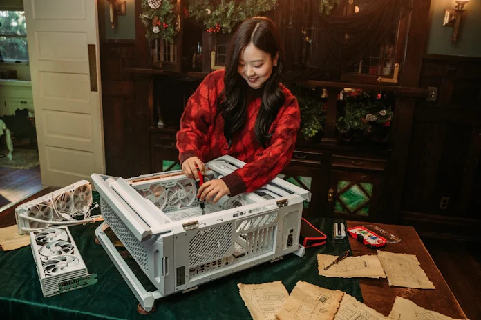 A young woman uses a screwdriver as she builds a PC