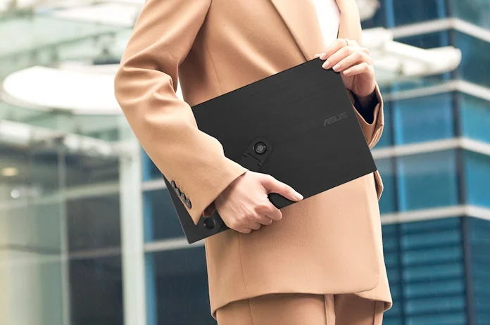 A person in business attire holding a ZenScreen portable monitor