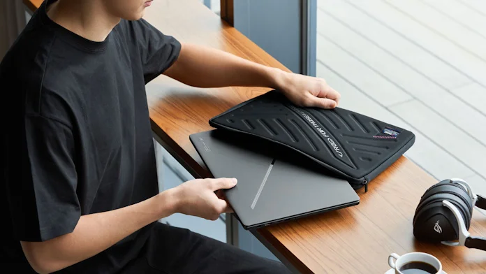 The ROG Zephyrus G15 laptop being pulled out of its sleeve by a young man