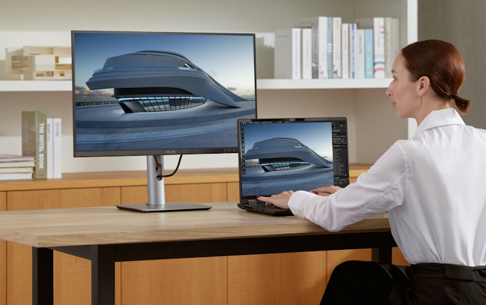 A woman uses the ProArt PA32QCV on a desk