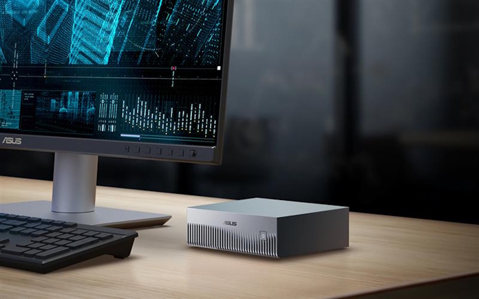 The ASUS Ascent GX10 AI supercomputer on a desk with other computer equipment