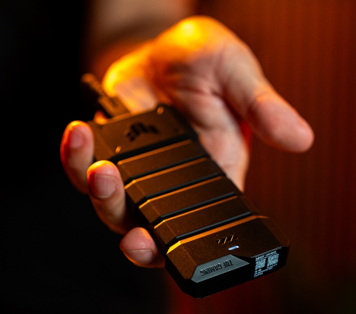 A man holds out the TUF Gaming A2 portable SSD enclosure in his hand