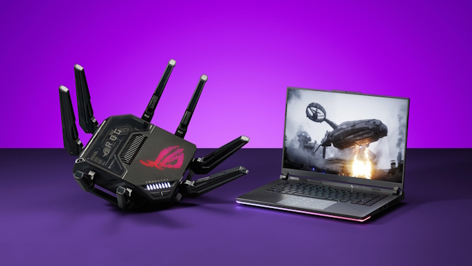 The ROG Rapture GT-BE98 Pro gaming router on a table next to an ROG laptop