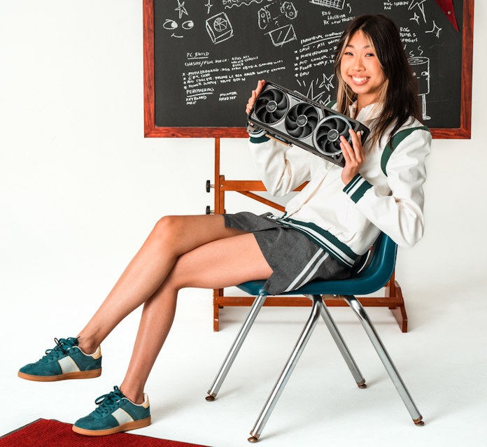 A student sits in a chair, holding one of today's powerful GPUs in her hands