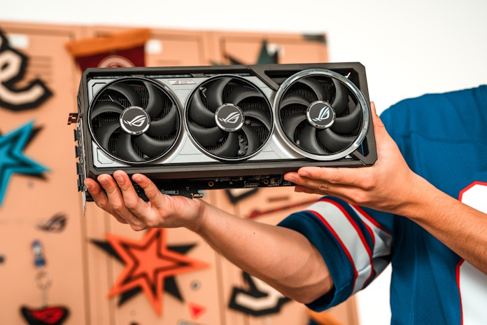 A young man holding a ROG graphics card