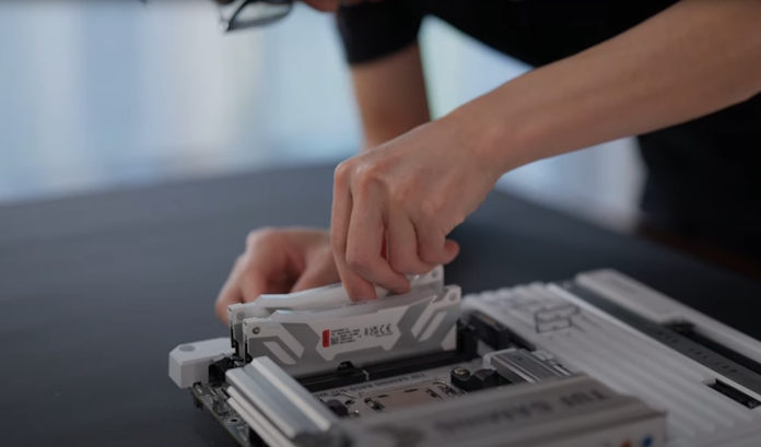 A young man installs memory onto his motherboard
