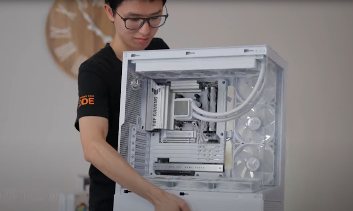 A young man moves a PC in the process of being built