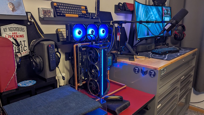 A side view of this open air PC build, with a garage workbench and PC gear in the background
