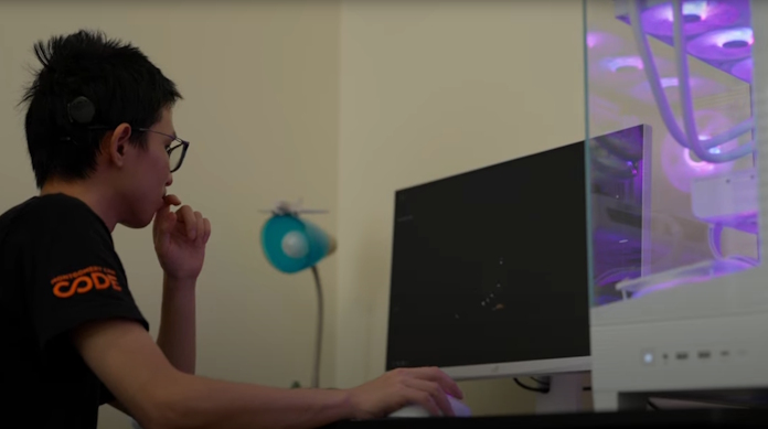 A young man looks at his screen as he works on an astronomy simulation