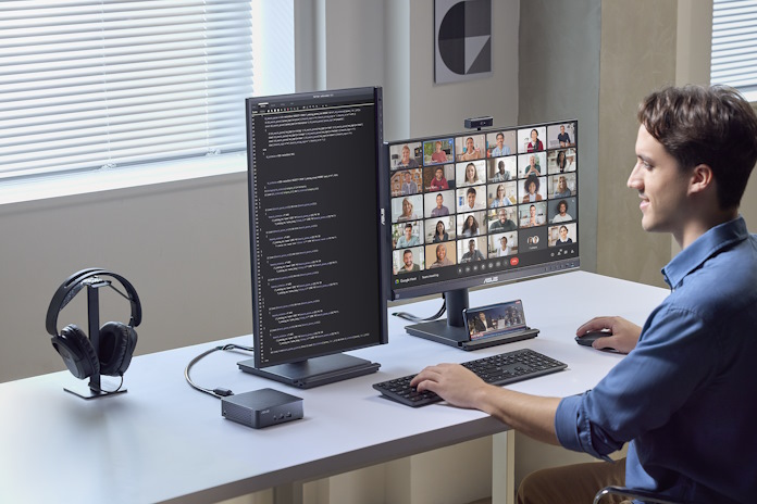 A man works on code while participating in a video conference