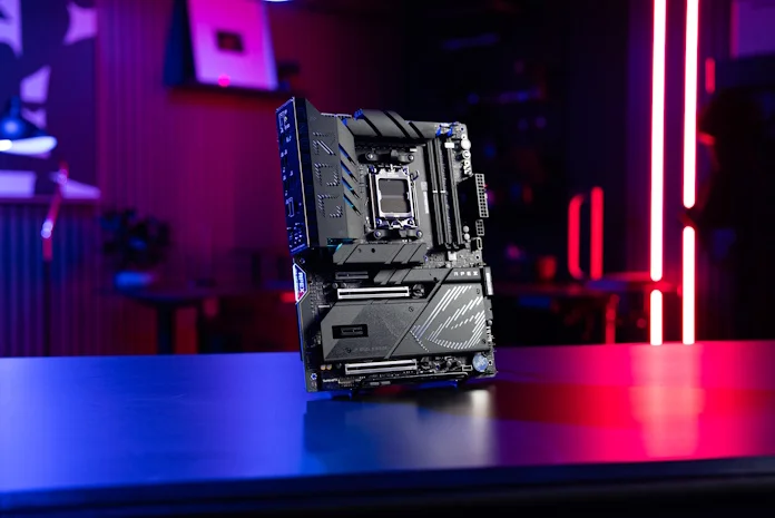 The ROG Crosshair X870E Apex gaming motherboard on a table in a gaming room