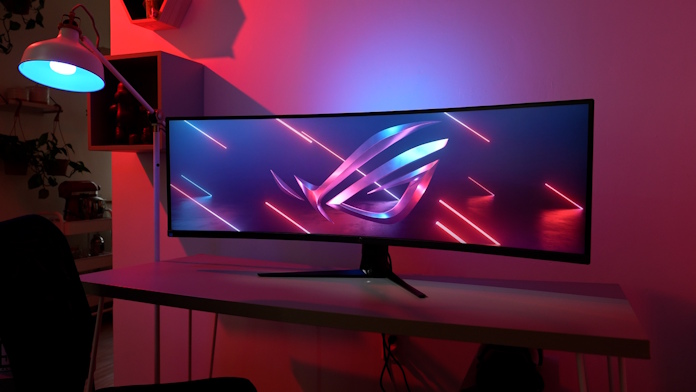 The ROG Strix XG49WCR gaming monitor on a desk