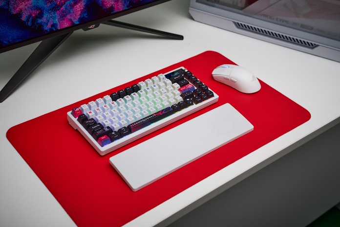 An ROG Azoth keyboard on a red mousepad with the ROG Harpe Ace II gaming mouse