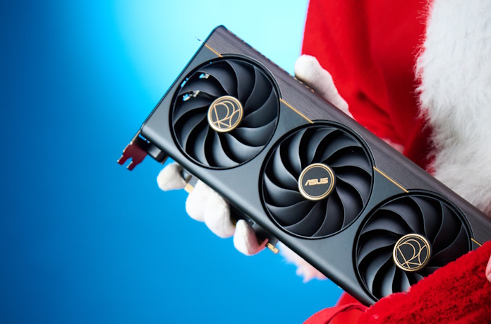 A man in a Santa costume holding out the ProArt GeForce RTX 5070 Ti graphics card