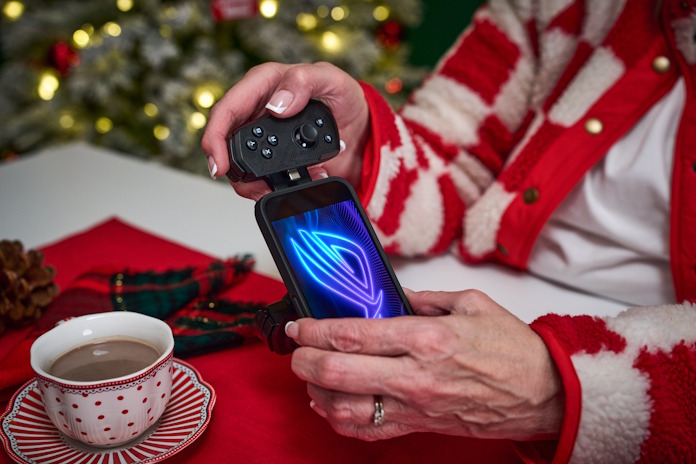 A woman connecting the ROG Tessen to an ROG Phone in a room decorated for the holidays