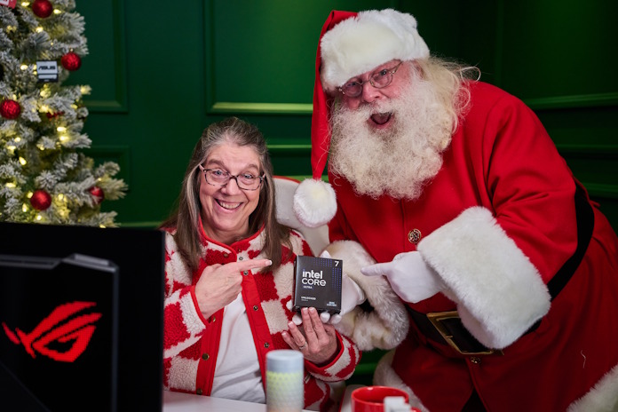 A woman poses with Santa while they both hold an Intel gaming CPU together